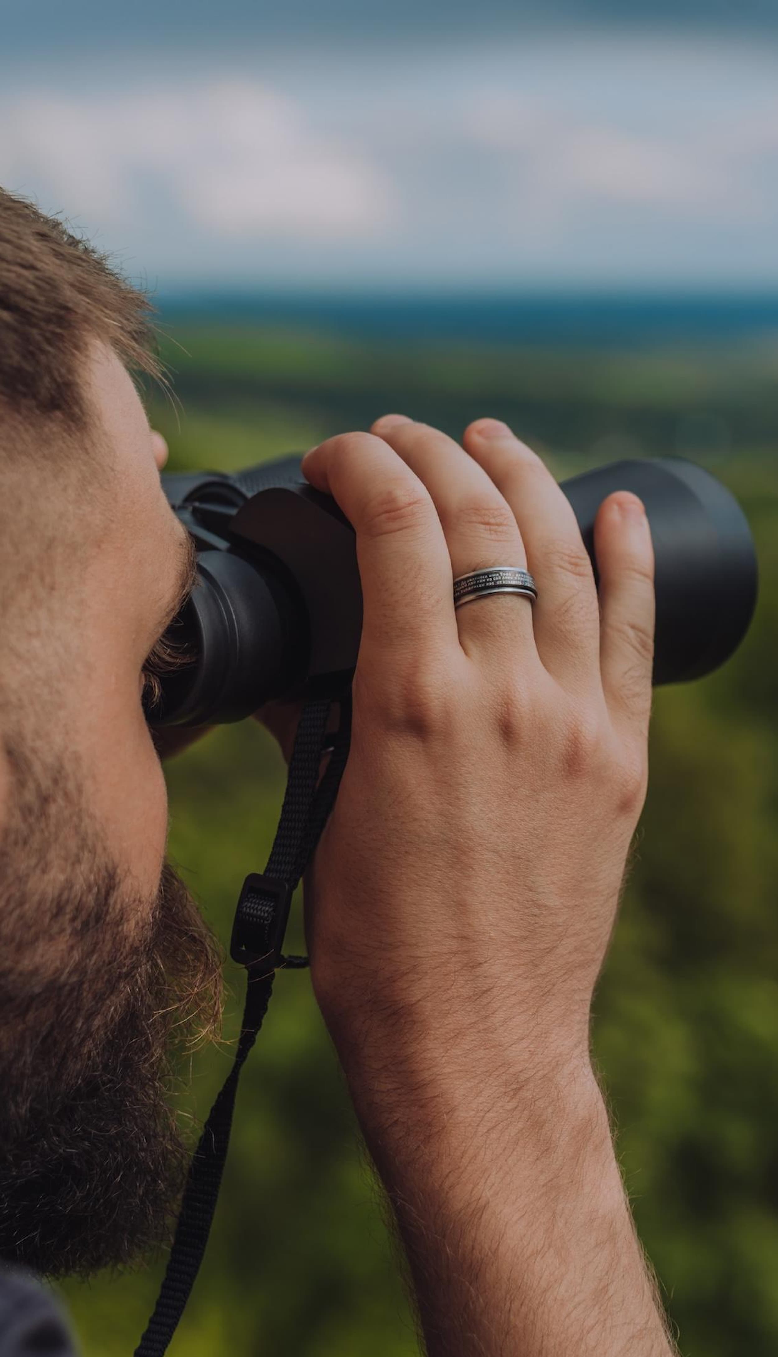 Wandelaar kijkt met een verrekijker uit over het landschap